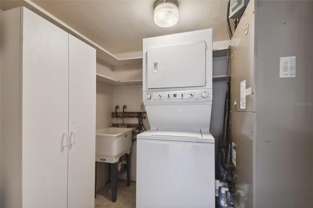 laundry room with light tile patterned floors and stacked washer / drying machine