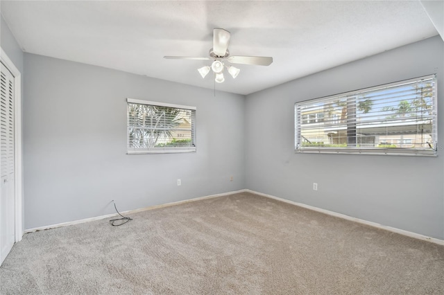 unfurnished room featuring carpet flooring, ceiling fan, and a healthy amount of sunlight