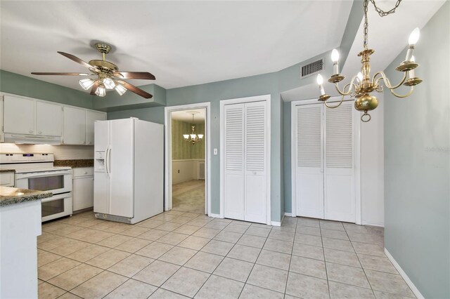 kitchen with ceiling fan with notable chandelier, pendant lighting, white appliances, light tile patterned floors, and white cabinetry