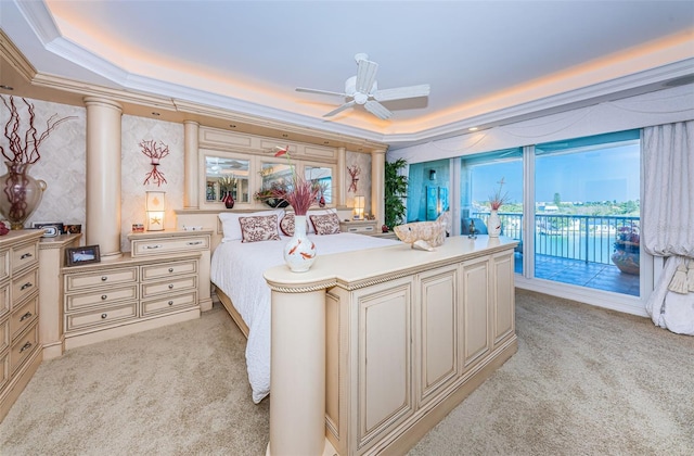 carpeted bedroom featuring a tray ceiling, ceiling fan, access to exterior, and multiple windows