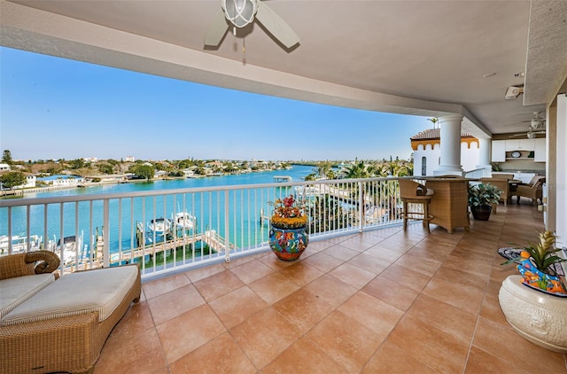 balcony with a water view and ceiling fan