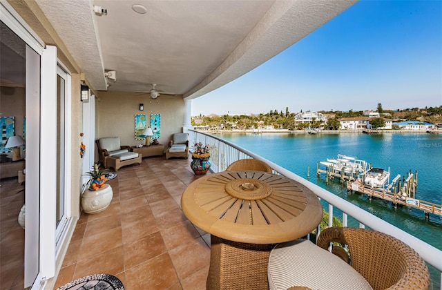 balcony featuring a water view, ceiling fan, and a boat dock