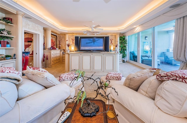 living room featuring a raised ceiling, ceiling fan, and light carpet