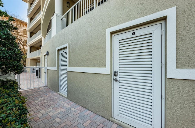 view of exterior entry with a balcony