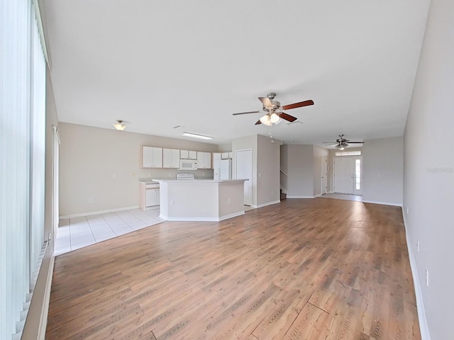 unfurnished living room with ceiling fan and light tile floors