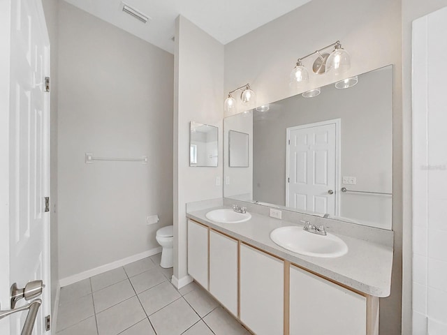 bathroom featuring toilet, dual bowl vanity, and tile flooring