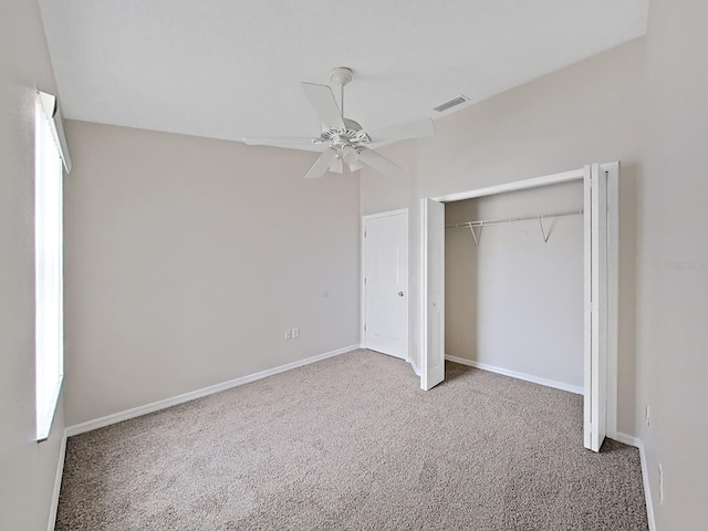 unfurnished bedroom featuring ceiling fan, a closet, and dark colored carpet