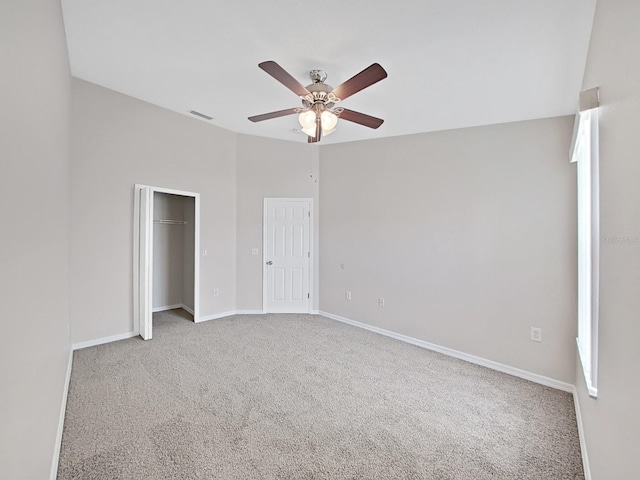 carpeted spare room with ceiling fan