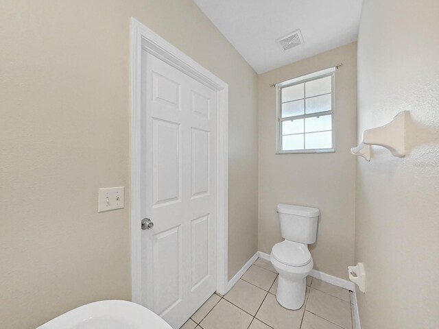 bathroom featuring tile floors and toilet