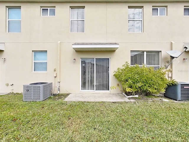 rear view of house featuring a yard and central air condition unit