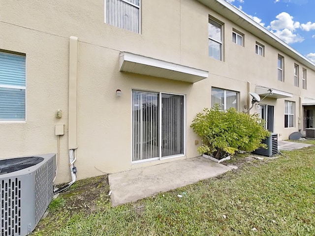 rear view of property featuring central AC and a yard