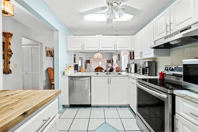 kitchen with tasteful backsplash, ceiling fan, stainless steel appliances, light tile floors, and white cabinets