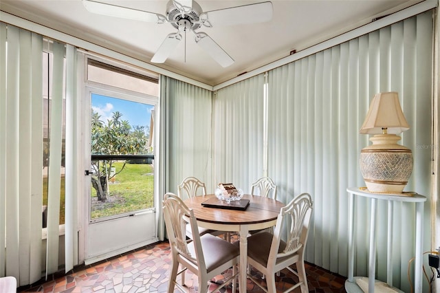 dining room with dark tile floors and ceiling fan