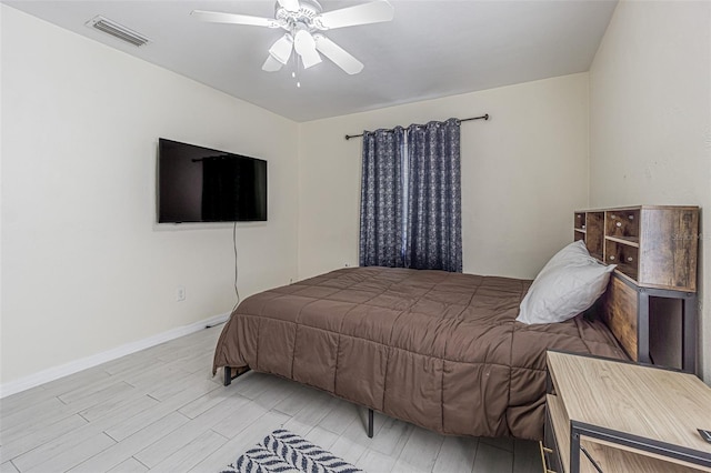 bedroom with a ceiling fan, light wood-style floors, visible vents, and baseboards