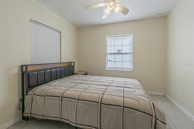 bedroom featuring wood finished floors, baseboards, and ceiling fan