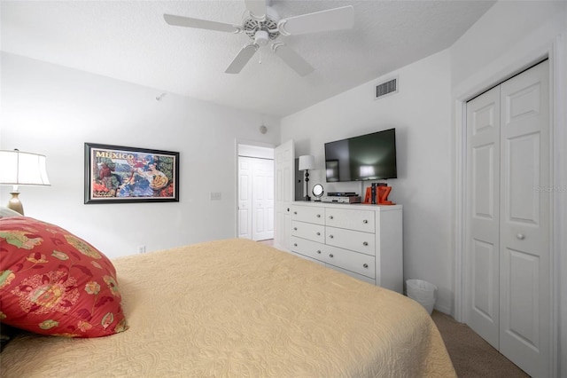 carpeted bedroom with ceiling fan and a textured ceiling