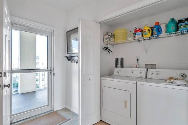 laundry area with washer and dryer, a healthy amount of sunlight, and light wood-type flooring