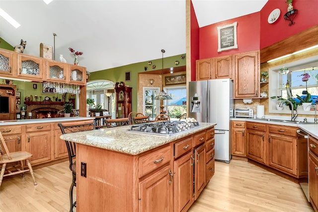 kitchen featuring plenty of natural light, a kitchen island, light hardwood / wood-style floors, and stainless steel appliances