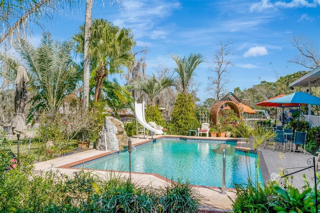 view of swimming pool with a patio area and a water slide