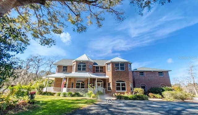 view of front of home with a porch and a front lawn