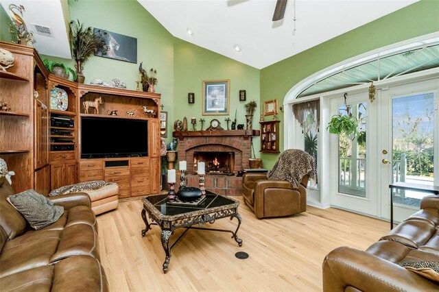 living room featuring a fireplace, hardwood / wood-style floors, ceiling fan, and lofted ceiling