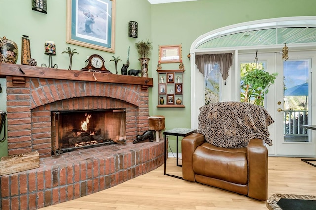 living area with hardwood / wood-style floors and a brick fireplace