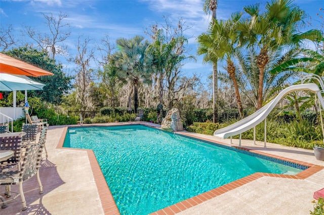 view of pool with a patio area and a water slide