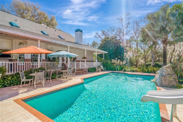 view of pool featuring a patio area and a water slide