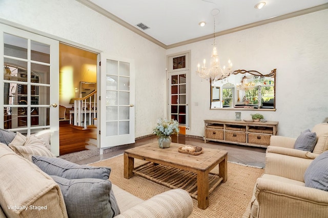 living room with hardwood / wood-style floors, a chandelier, and ornamental molding