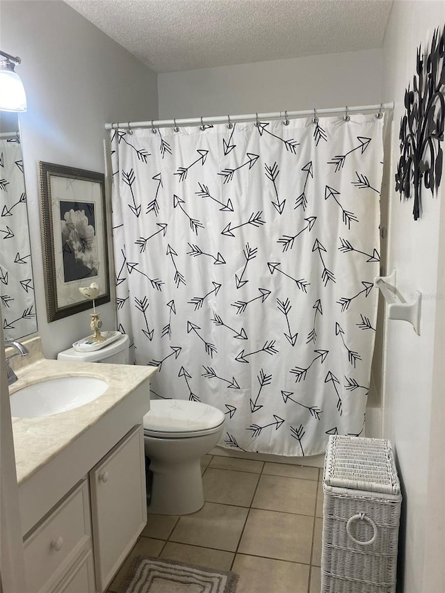 bathroom with oversized vanity, toilet, a textured ceiling, and tile flooring