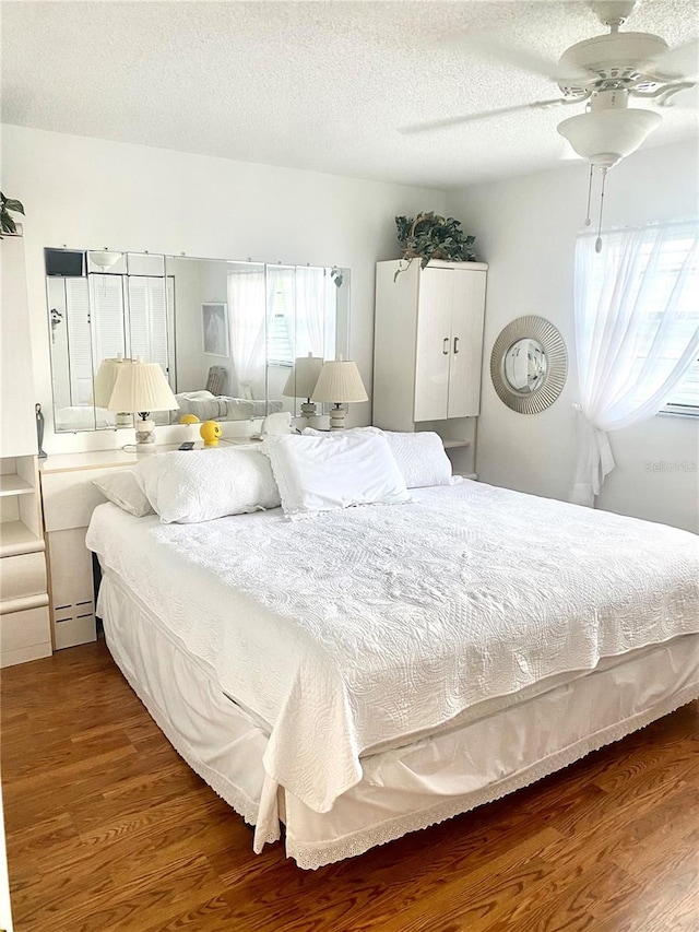 bedroom featuring a textured ceiling, ceiling fan, and hardwood / wood-style flooring