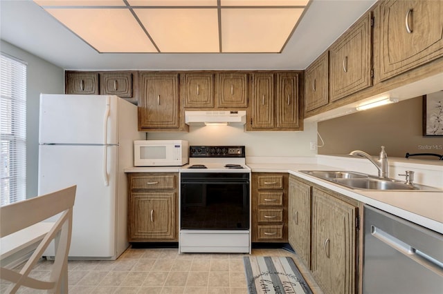 kitchen featuring white appliances, sink, and light tile floors