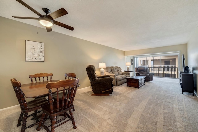 carpeted dining space with a textured ceiling and ceiling fan