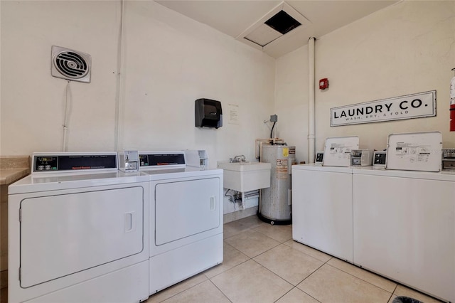 laundry room with light tile flooring, independent washer and dryer, water heater, and sink