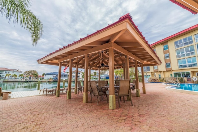 view of home's community with a water view, a boat dock, and a pool