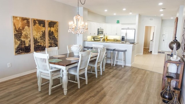 dining area featuring a notable chandelier and light hardwood / wood-style flooring