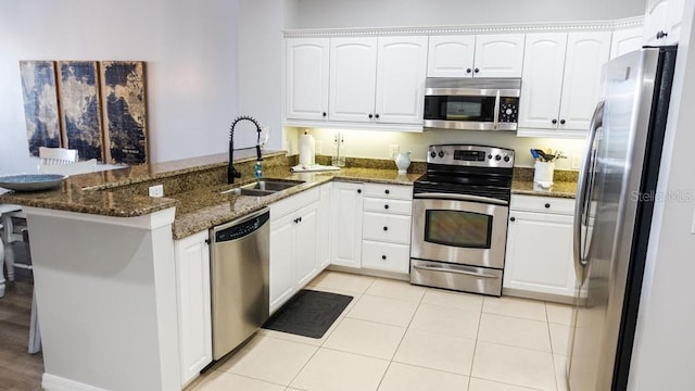 kitchen with white cabinets, kitchen peninsula, sink, and stainless steel appliances