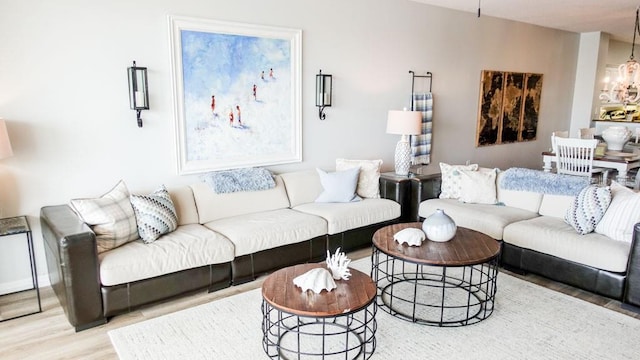 living room with an inviting chandelier and light hardwood / wood-style flooring