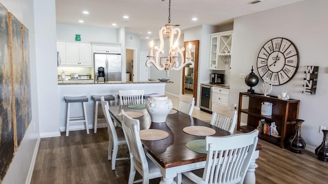 dining space featuring dark hardwood / wood-style floors, a notable chandelier, and beverage cooler