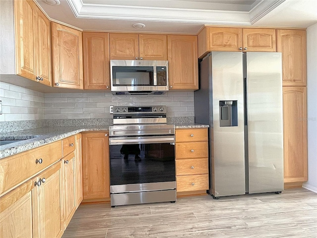 kitchen featuring stainless steel appliances, light wood finished floors, light stone counters, and tasteful backsplash