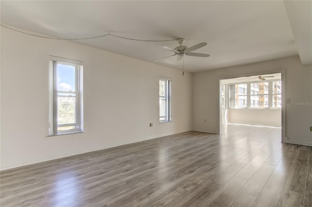 unfurnished room with light wood finished floors and a ceiling fan