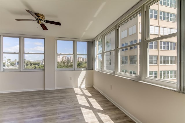 unfurnished sunroom with ceiling fan and a healthy amount of sunlight