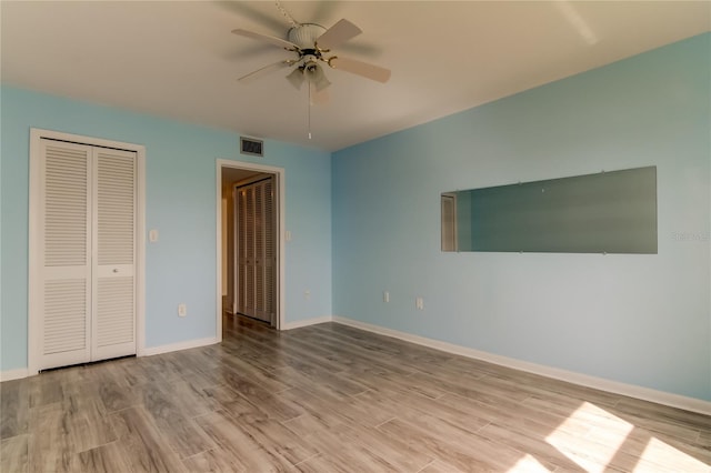 unfurnished bedroom with visible vents, ceiling fan, light wood-style flooring, and baseboards