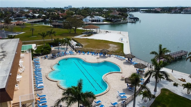 view of swimming pool featuring a water view and a patio area