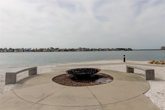 view of patio with a water view and a fire pit