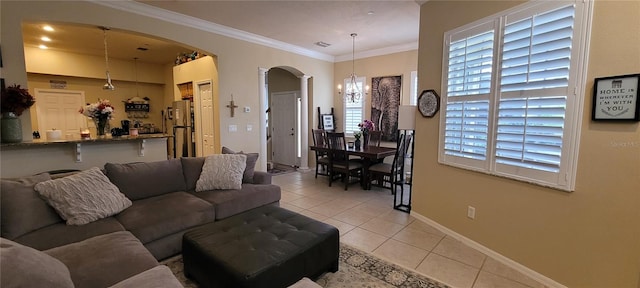 tiled living room with crown molding and an inviting chandelier