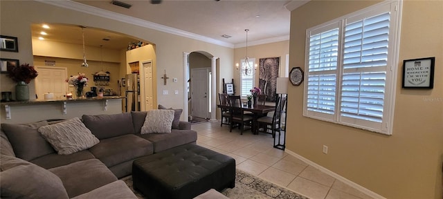 tiled living room featuring an inviting chandelier and crown molding