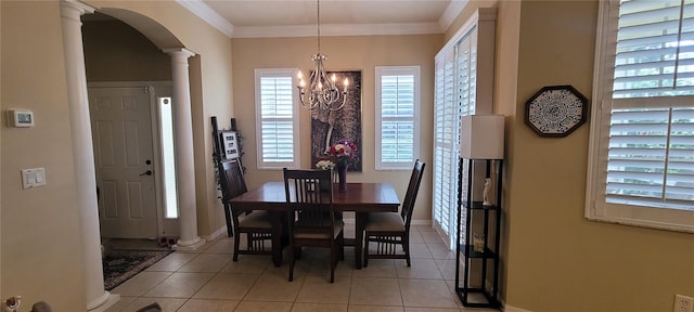 dining space featuring light tile floors, a chandelier, crown molding, and ornate columns