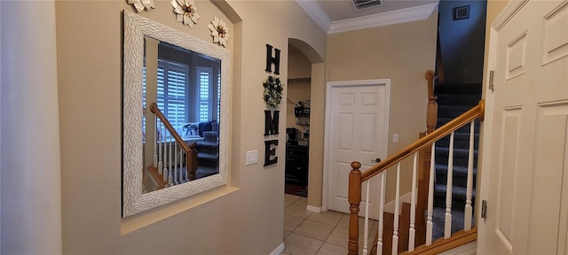 interior space with light tile floors and crown molding