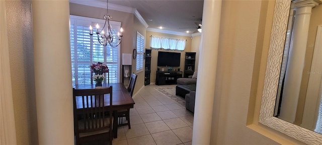 hallway featuring a chandelier, light tile floors, ornate columns, and crown molding